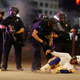 Denver Police Department officers clear a man who fell to the street after they used tear gas and rubber bullets to disperse a protest outside the State Capitol over the death of George Floyd.